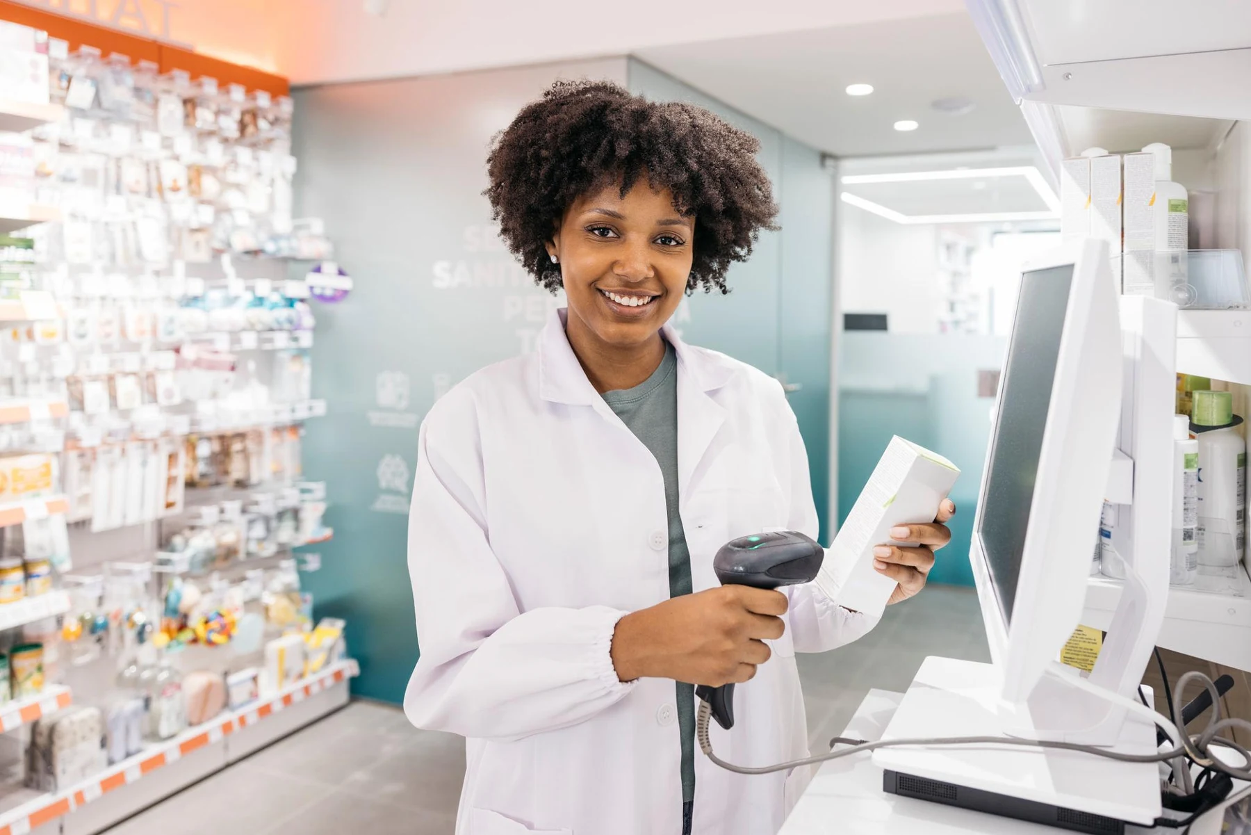Farmacéutica sonriente atendiendo en el mostrador de una farmacia.